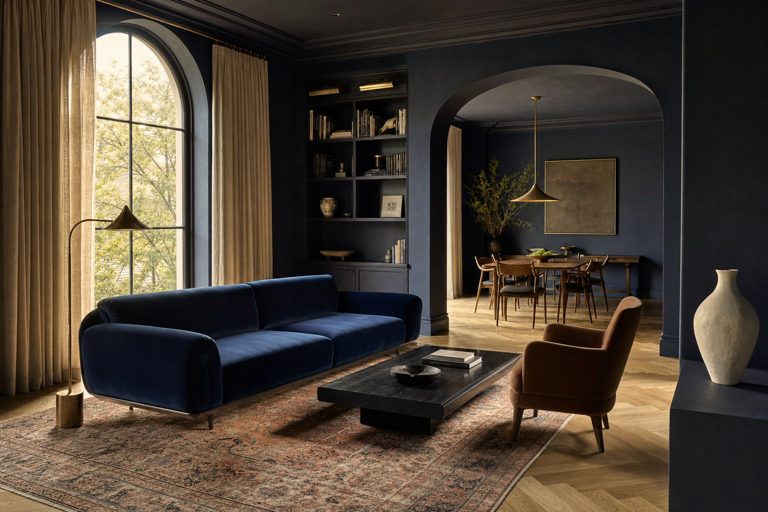 Midnight navy living room with deep blue velvet sofa, arched window, and salmon-toned vintage rug