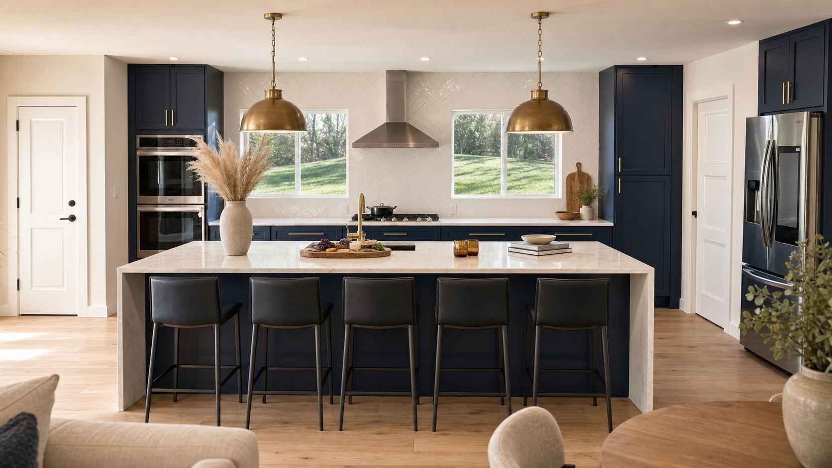 An open kitchen composition with a large island and brass pendants